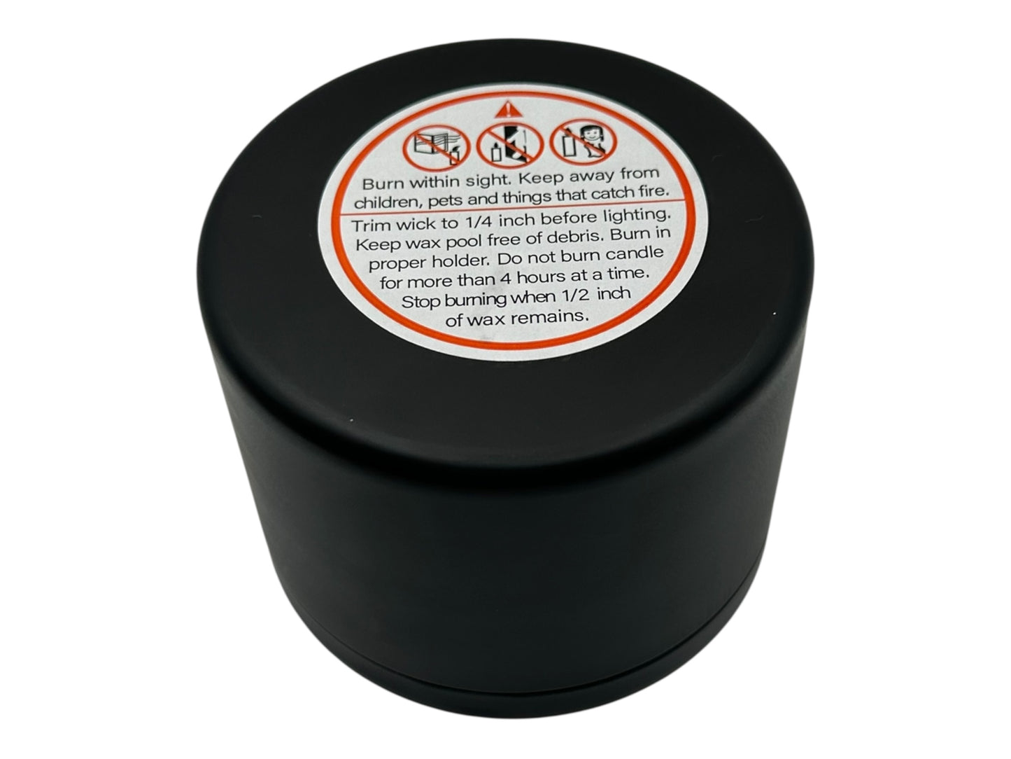 A black candle tin with a warning label on a white background