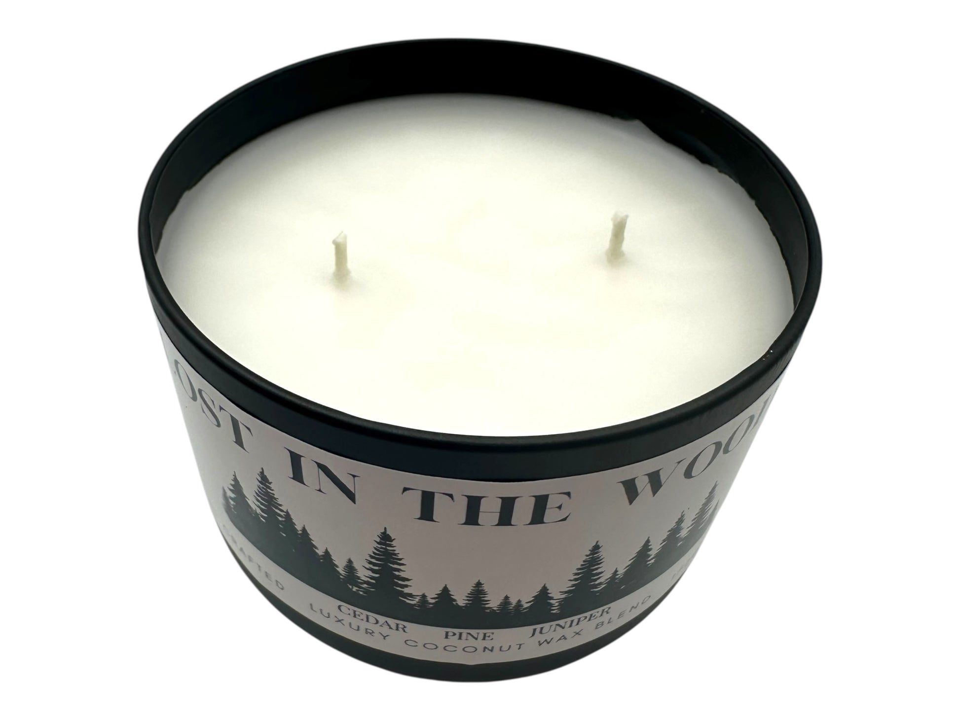 A black candle tin labeled "Lost in the Woods" with lid removed two wicks and as smooth candle top on a white background.