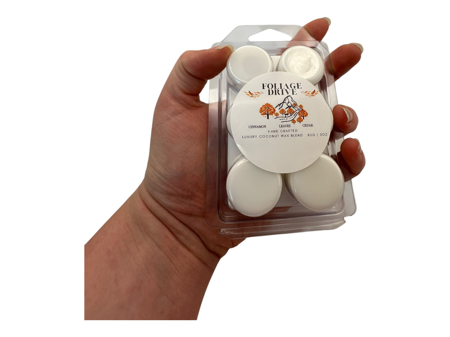 Hand holding a package of white wax melts with 'Foliage Drive' labeling.