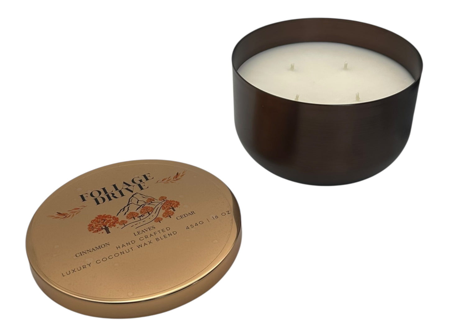 A bronze and gold candle tin labeled "Foliage Drive" with a decorative clear label lid on a white background.
