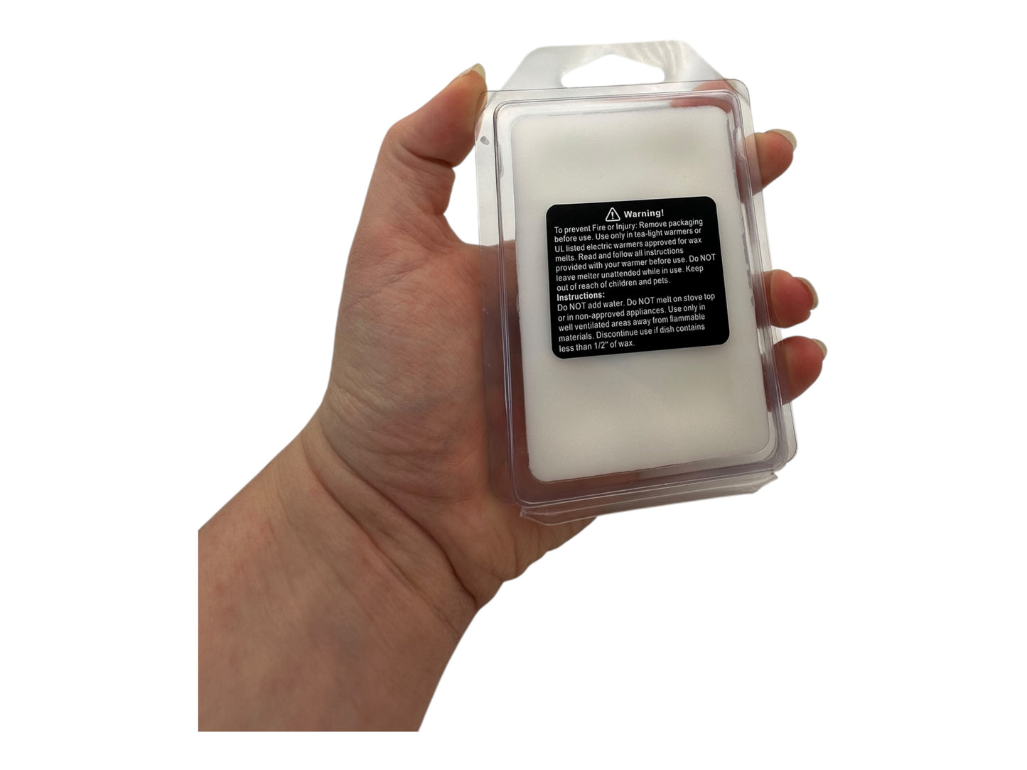 Hand holding a clear plastic packaging with white wax melts on a white background