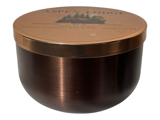 A bronze and gold candle tin labeled "Aspen Lodge" on a white background.