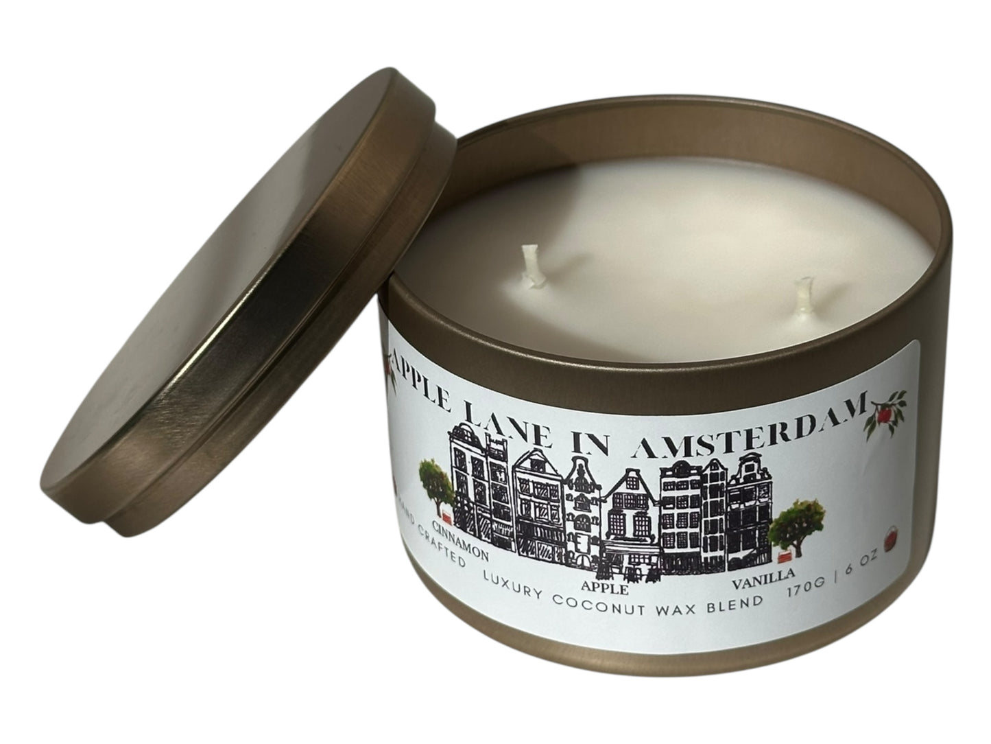 A gold candle tin with lid removed labeled "Apple Lane in Amsterdam" on a white background.