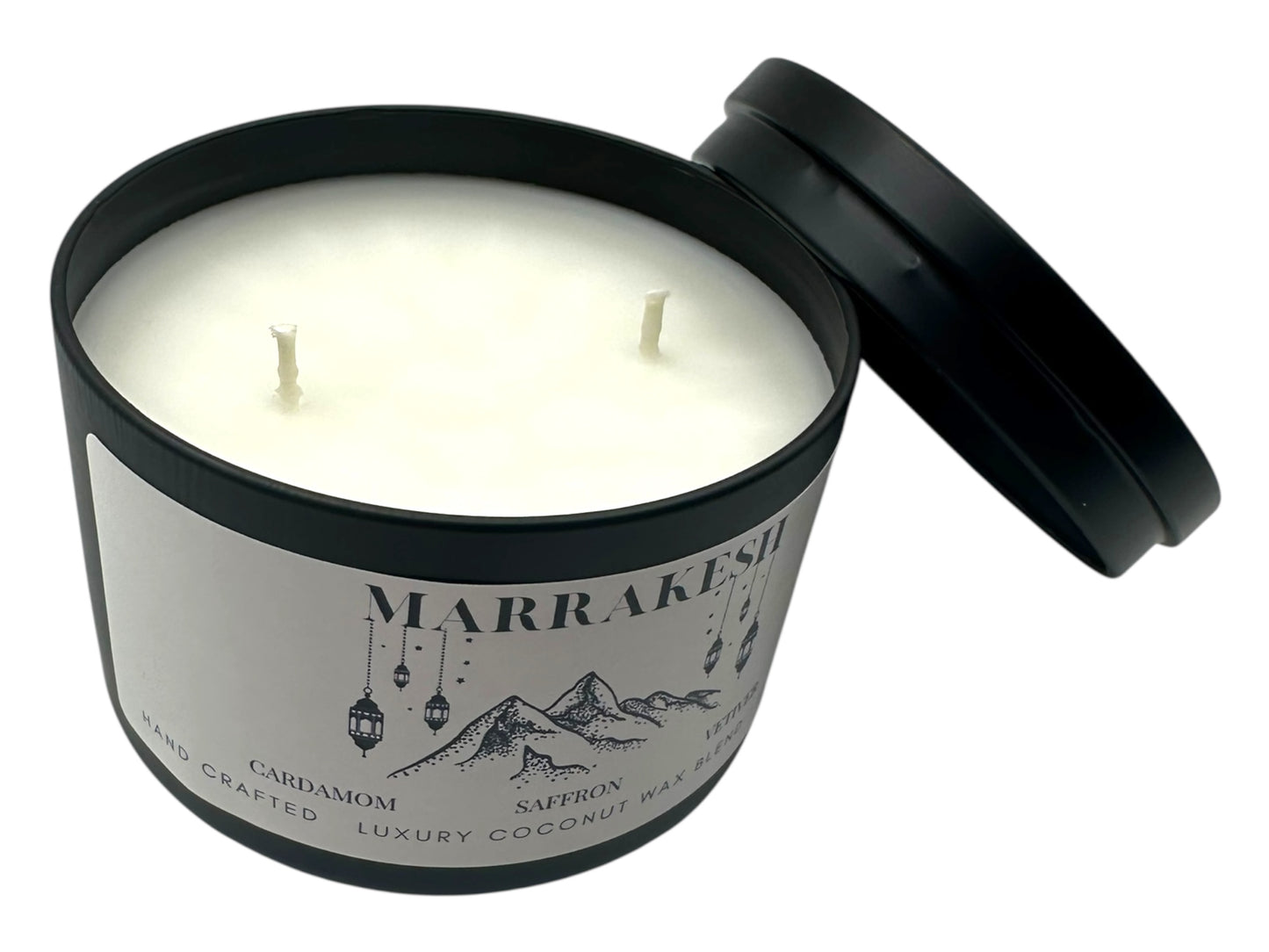 A black candle tin labeled "Marrakesh" lid removed two wicks and smooth white candle top on a white background.
