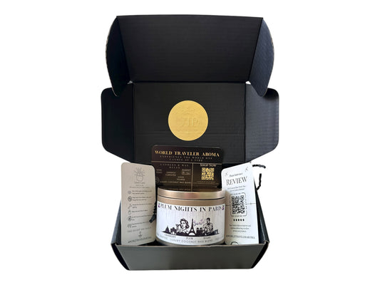 A black gift box with gold VIP sticker on the lid inside the box a gold candle tin labeled "Plum Nights in Paris" a candle care card instructions, a please review us card, and World Traveler Aroma business card on a white background.