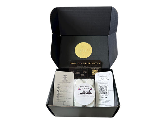 A black gift box with a golden VIP Sticker on the lid and inside the box a sugar plum scented wax melt labeled "Plum Nights in Pairs" a wax melt care instructions card, a please review us card, and World Traveler Aroma business
