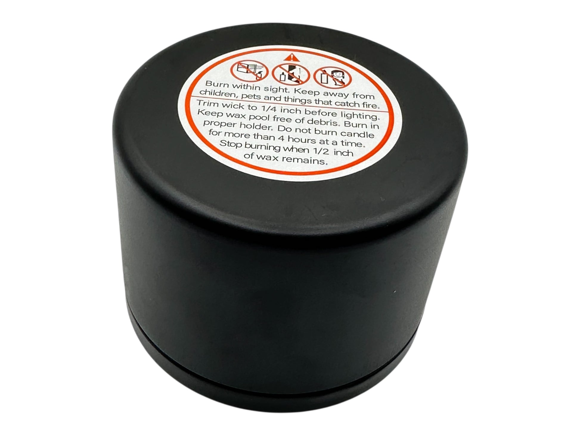 Black candle container with a warning label on a white background
