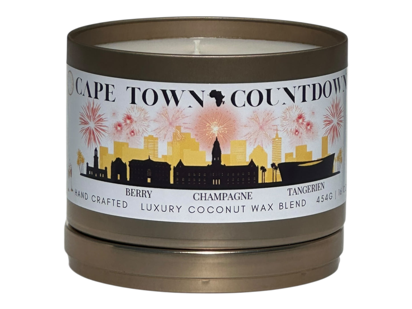 A new years gold candle tin labeled "Cape Town Countdown" on a white background top view with candle lid sitting underneath candle.