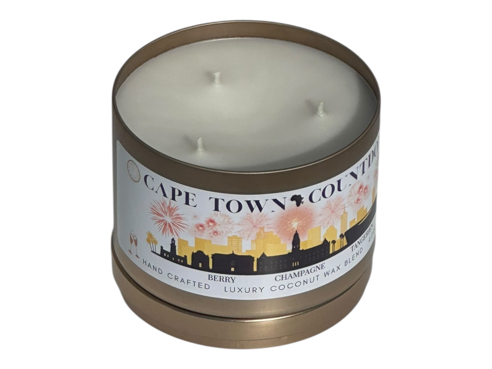 A new years gold candle tin labeled "Cape Town Countdown" on a white background top view with candle lid sitting underneath candle.