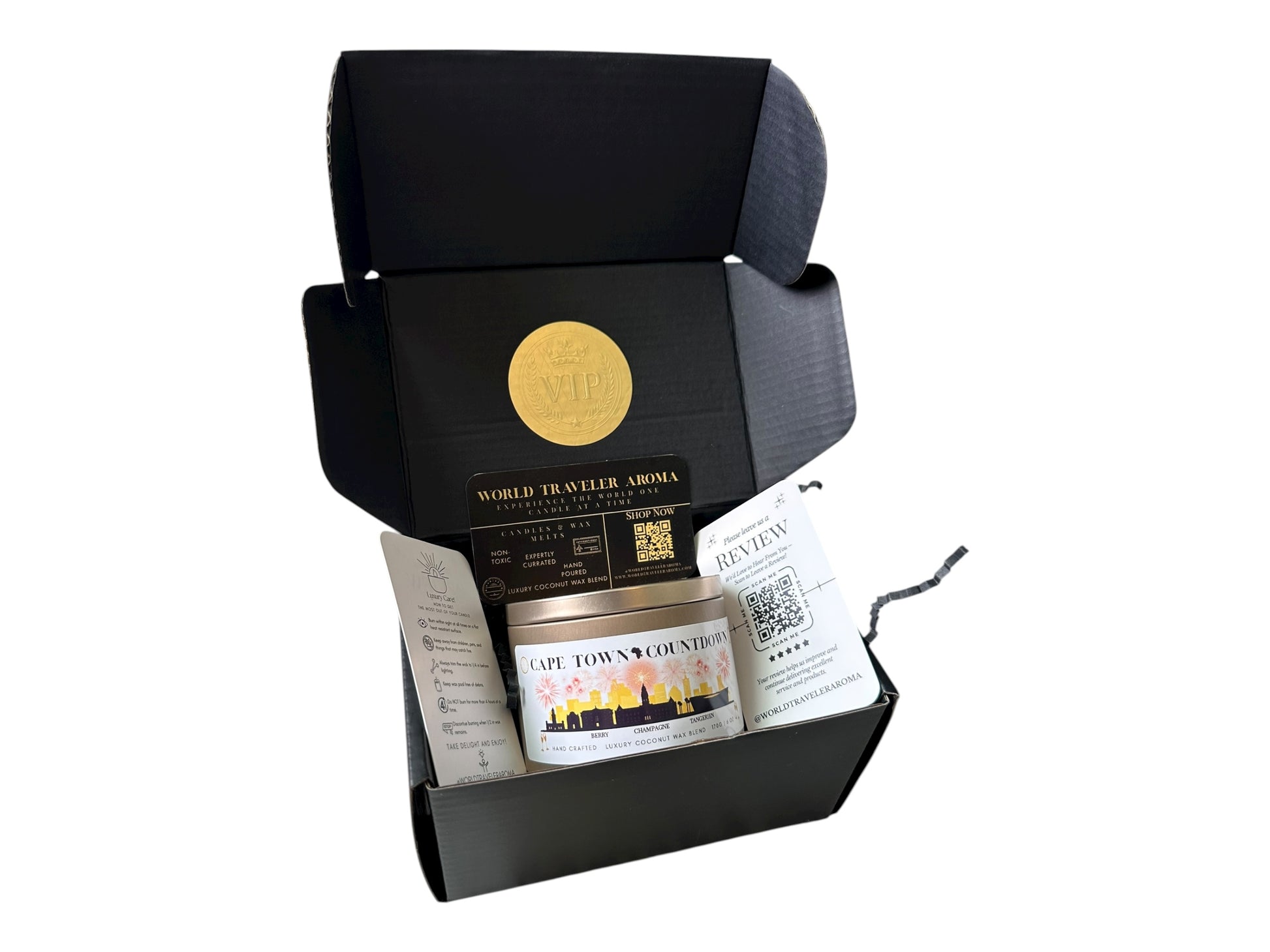 A black gift box with a gold VIP sticker on the lid inside the box a gold candle tin labeled "Cape Town Countdown" a candle care card instructions, a please review us card, and a World Traveler Aroma business card.