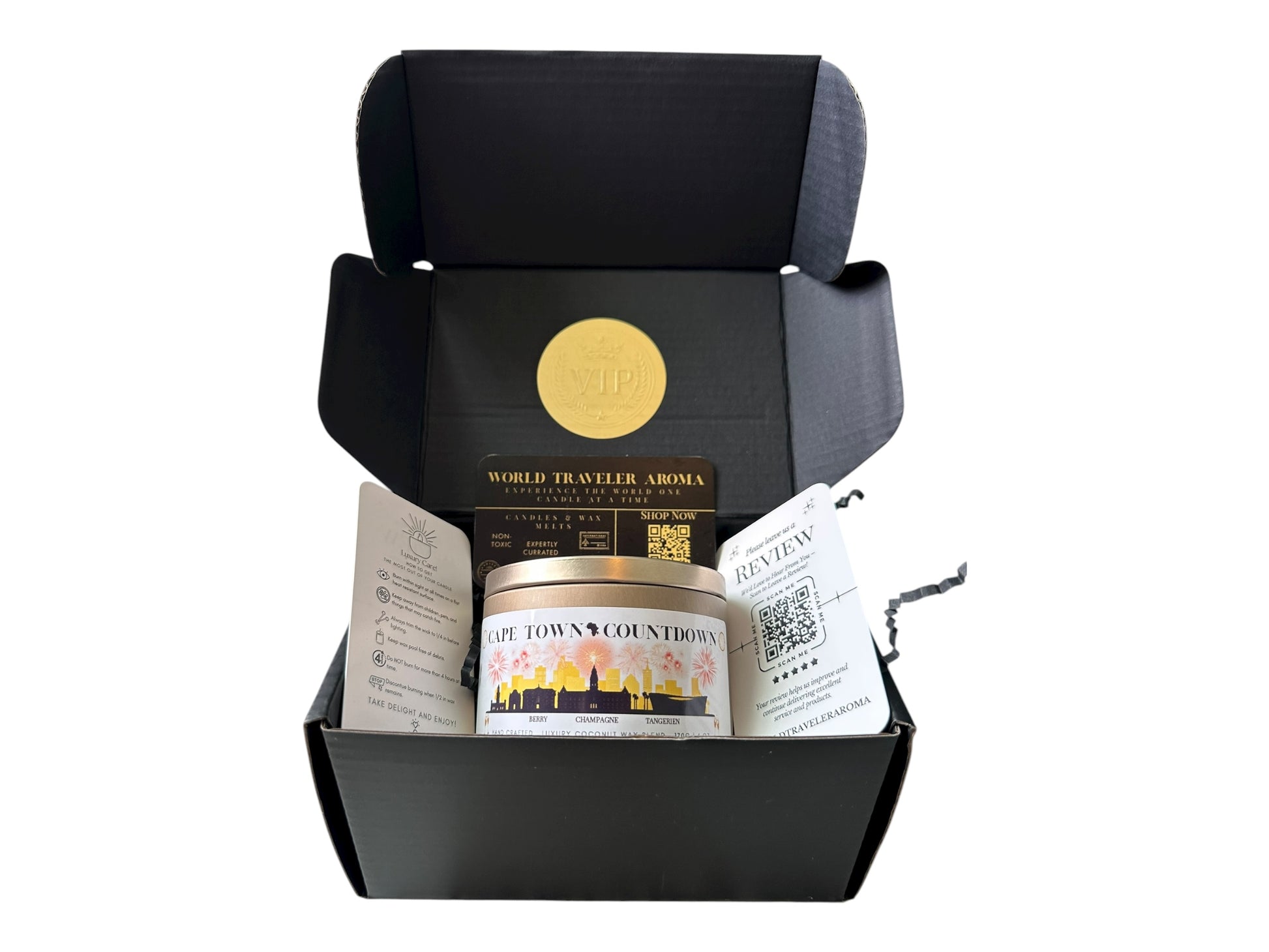  black gift box with a gold VIP sticker on the lid inside the box a gold candle tin labeled "Cape Town Countdown" a candle care card instructions, a please review us card, and a World Traveler Aroma business card.