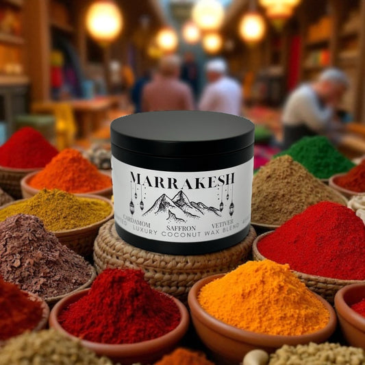 A black candle tin labeled Marrakesh surrounded by piles of spice in a spice market in the background.