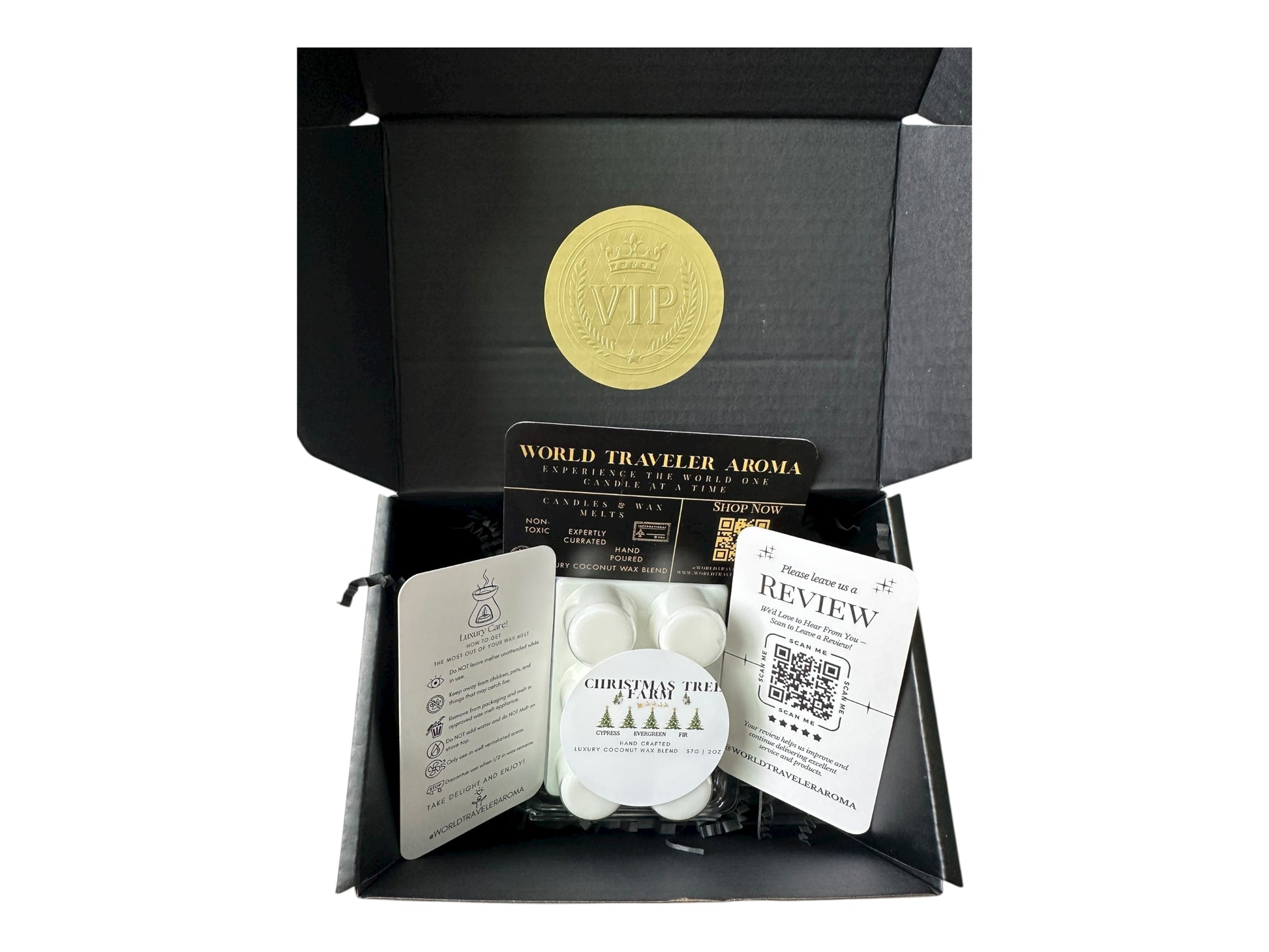 A holiday gift box with a golden VIP Sticker on the lid and inside the box a wax melt labeled "Christmas Tree Farm" Wax melt care card, please review us card, and World Traveler Aroma business card on a white background.