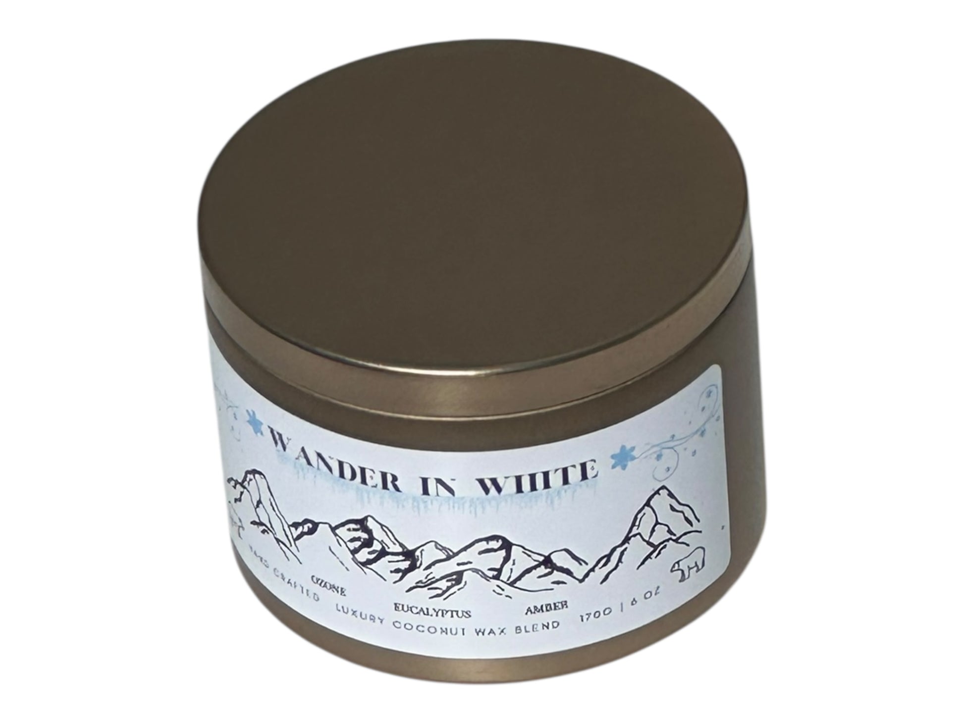 a gold Candle tin labeled 'Wander in White' with mountain design on a white background