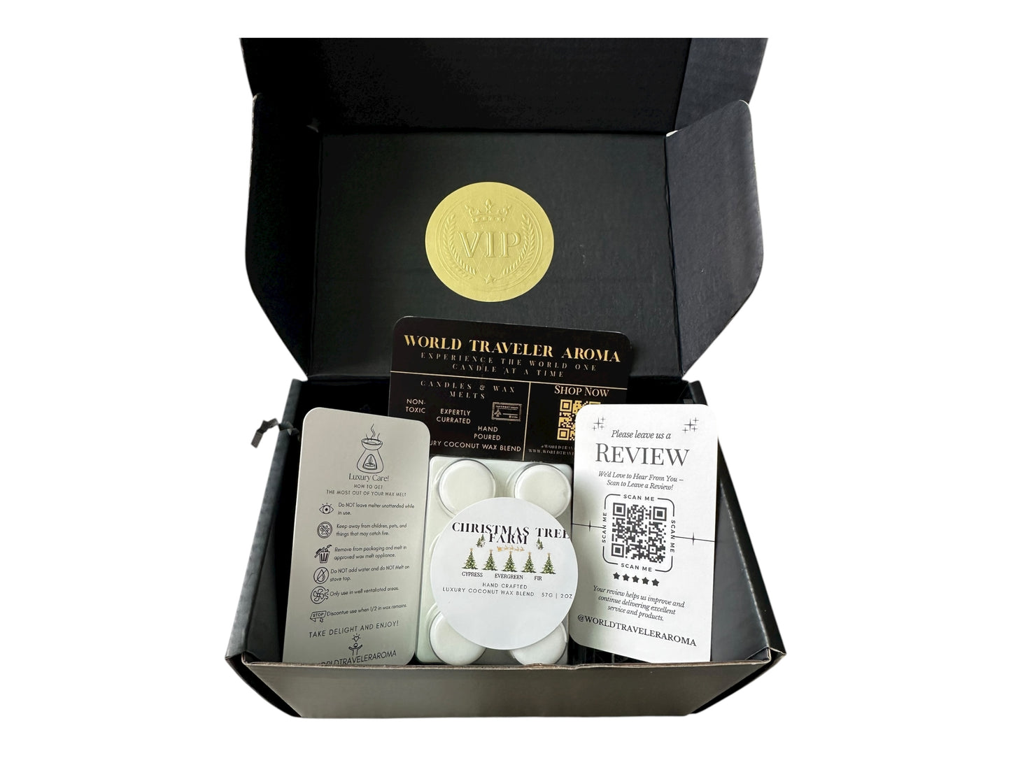 A holiday gift box with a golden VIP Sticker on the lid and inside the box a wax melt labeled "Christmas Tree Farm" Wax melt care card, please review us card, and World Traveler Aroma business card on a white background.