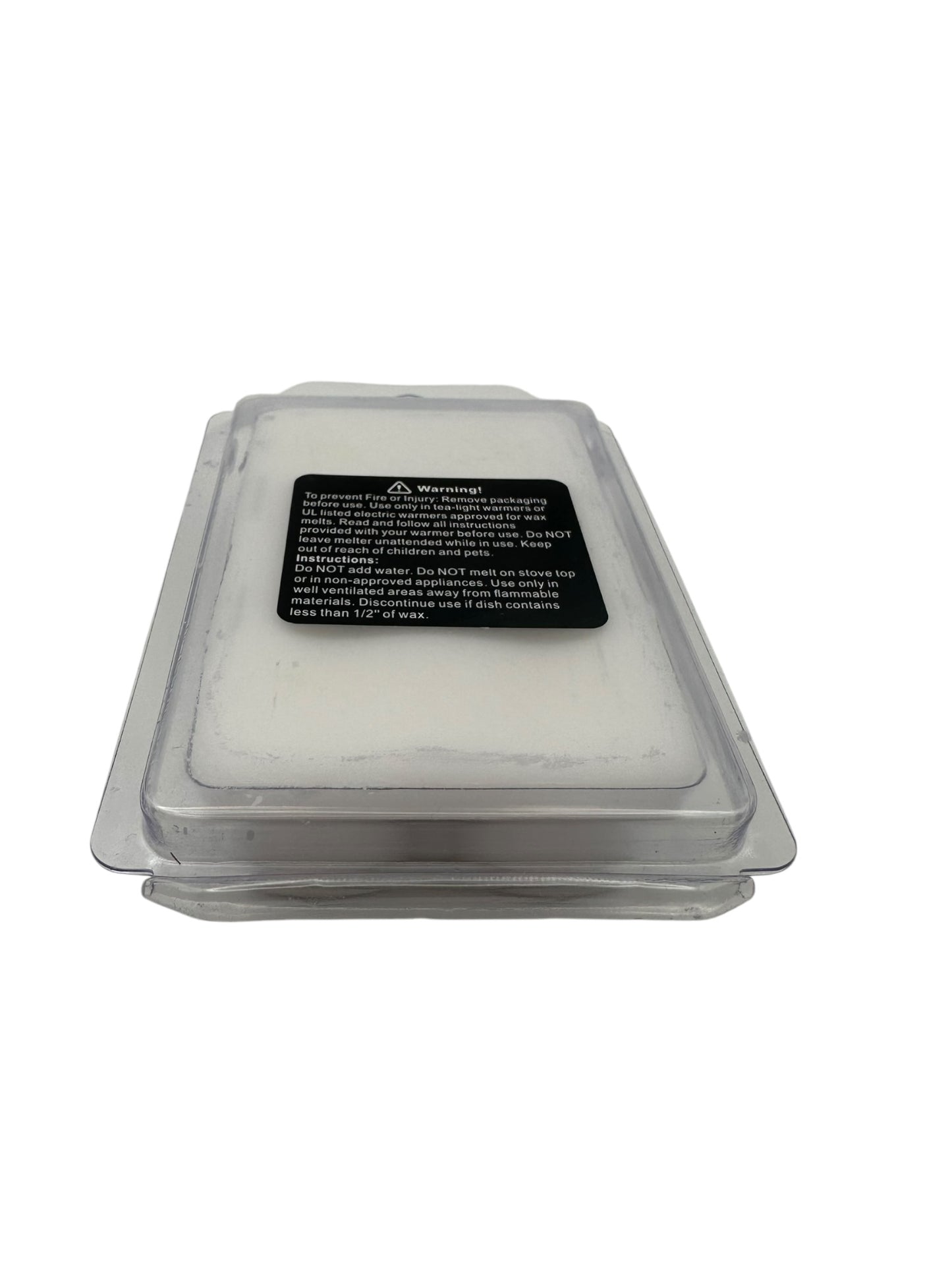 A plastic clamshell of white wax melts with a safety warning label on a white background. 