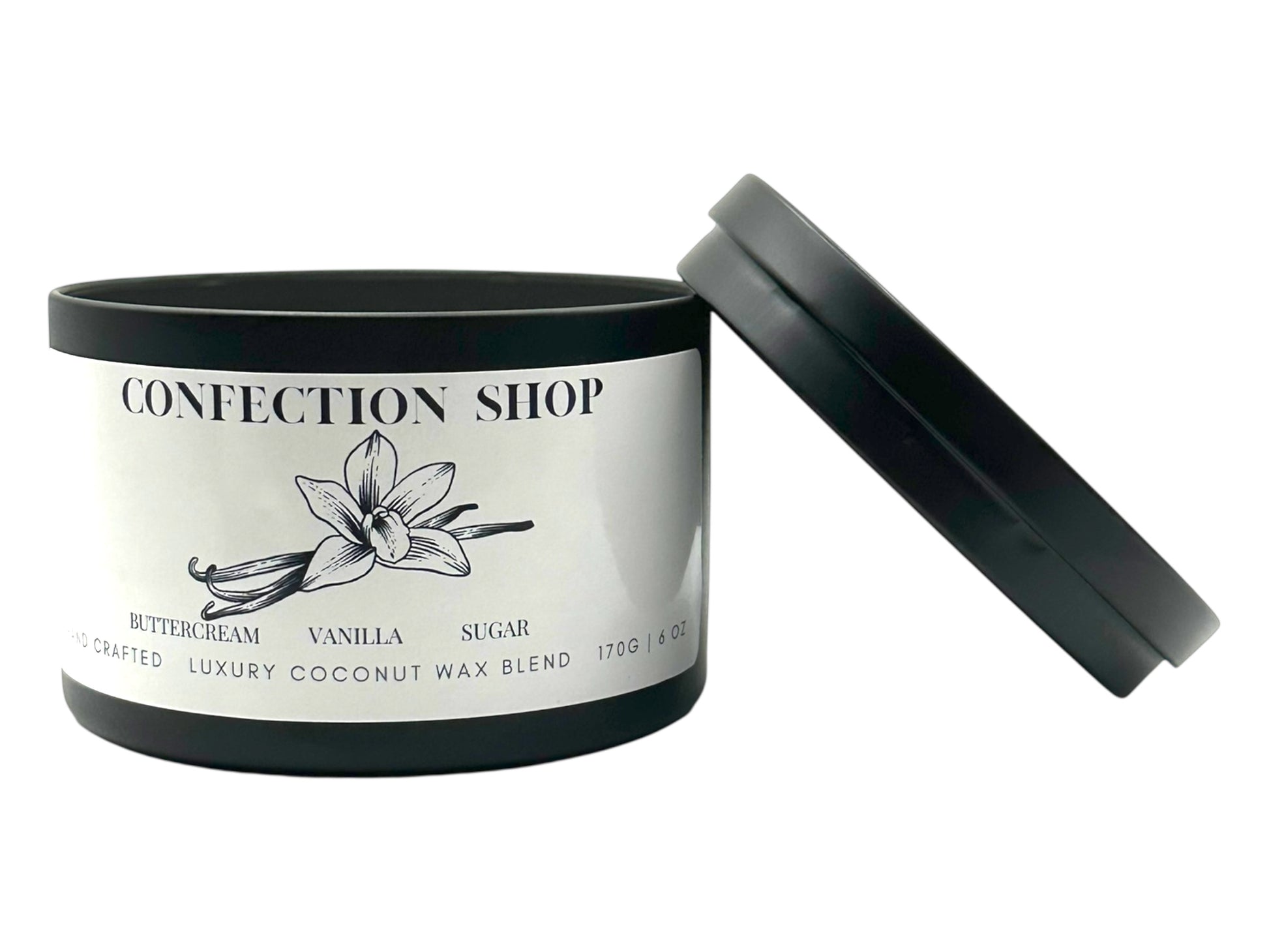A black candle tin labeled "Confection Shop" lid removed and lying next to the candle on a white background. 