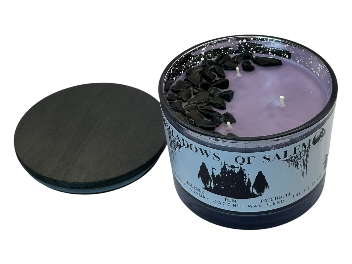 A purple candle in a glass jar with a label titled 'Shadows of Salem' on a white background.