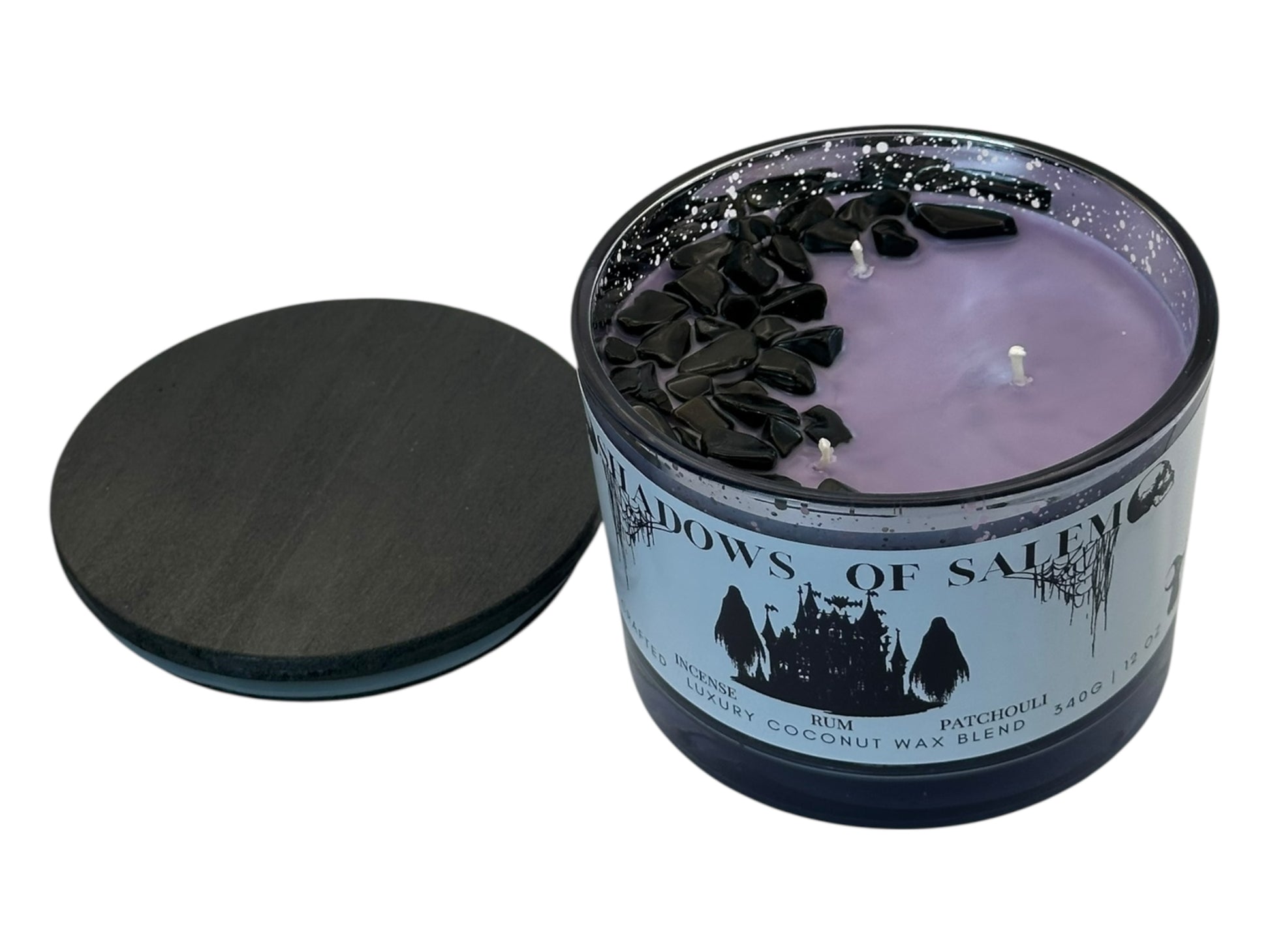 A purple candle in a glass jar with a label titled 'Shadows of Salem' on a white background.