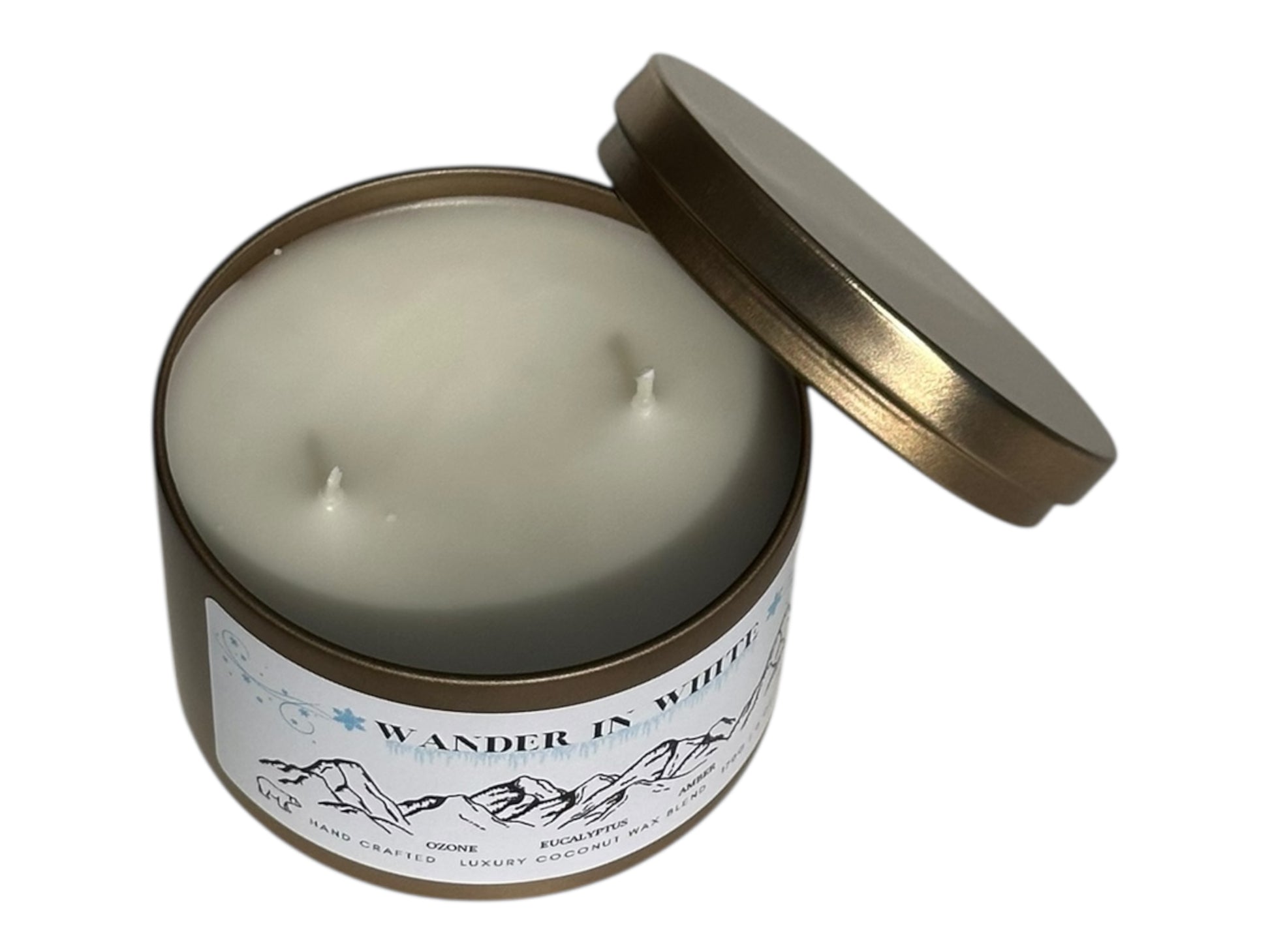 A gold candle tin labeled "Wander in White" with lid removed displaying two candle wicks on top on a white background.