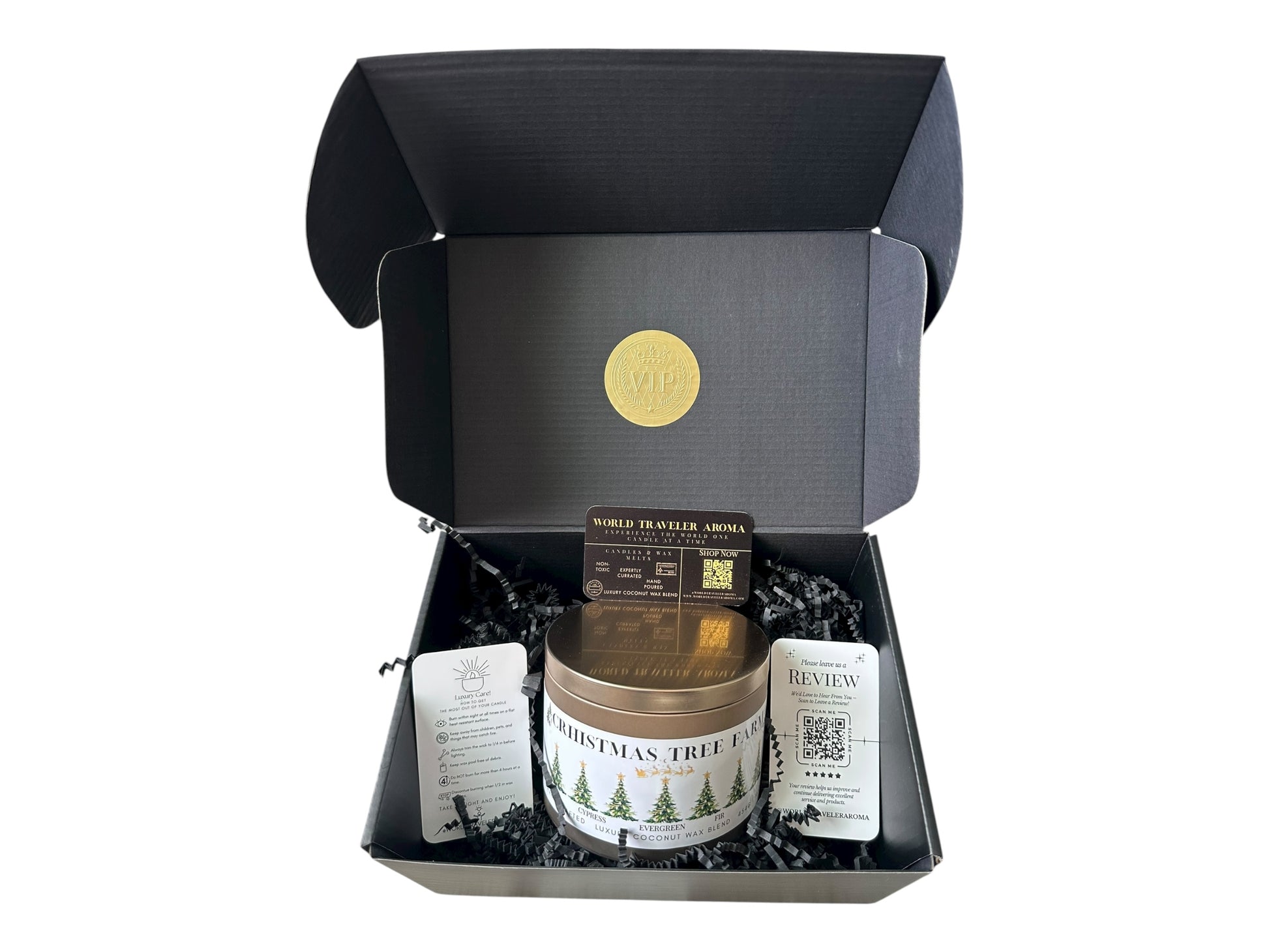 A black gift box with a gold VIP sticker on the lid inside the box a gold candle tin labeled "Christmas Tree Farm" a candle care care instructions, a please review us card, and a World Traveler Aroma business card on a white background.