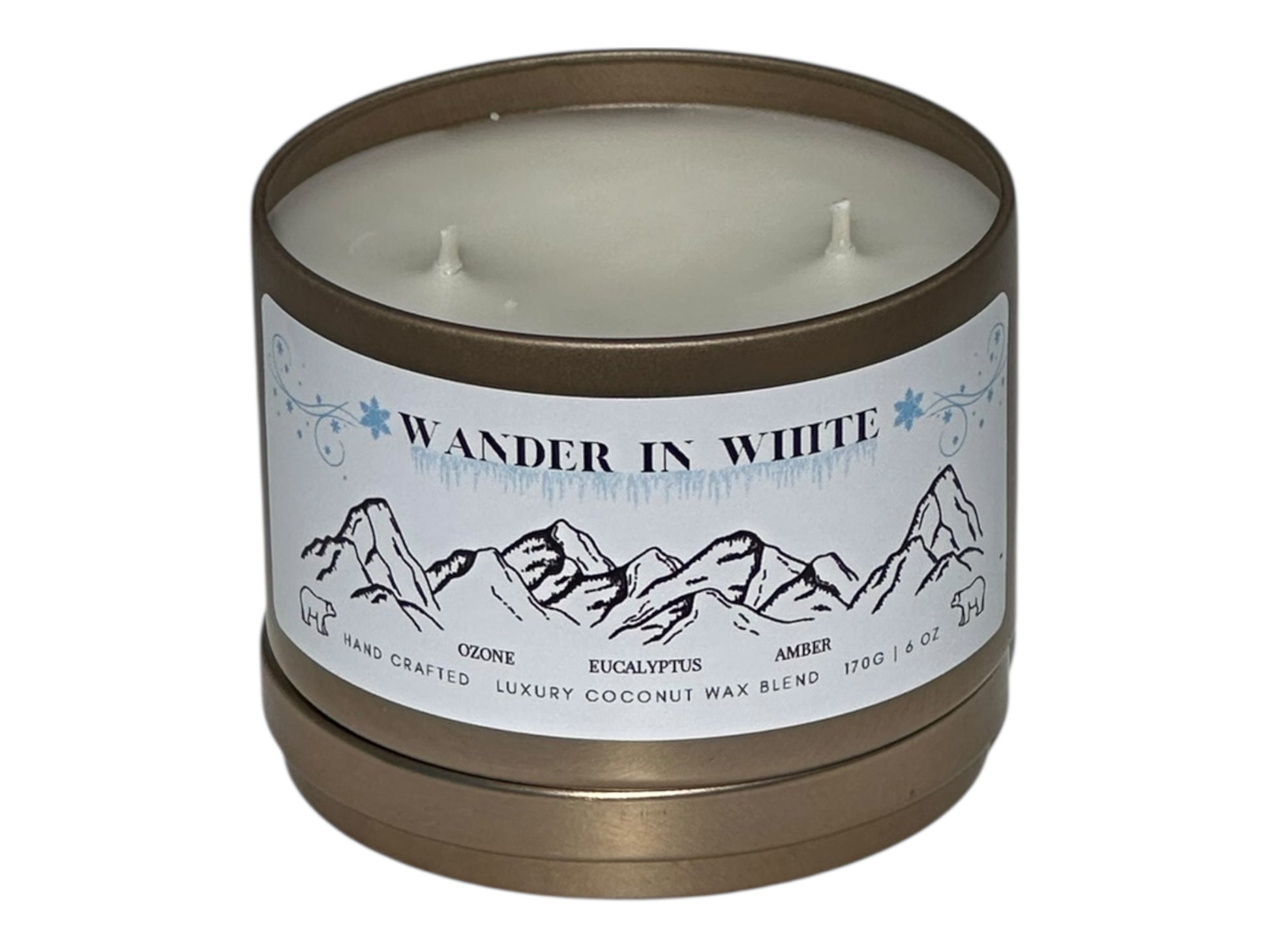 A gold candle tin labeled "Wander in White" with lid removed on a white background.