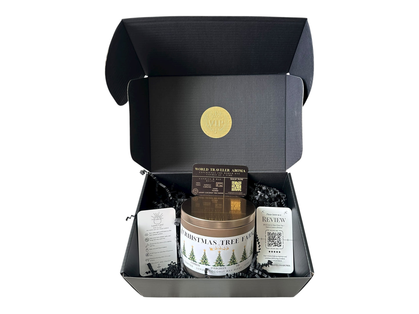 A black gift box with a gold VIP sticker on the lid inside the box a gold candle tin labeled "Christmas Tree Farm" a candle care care instructions, a please review us card, and a World Traveler Aroma business card on a white background.