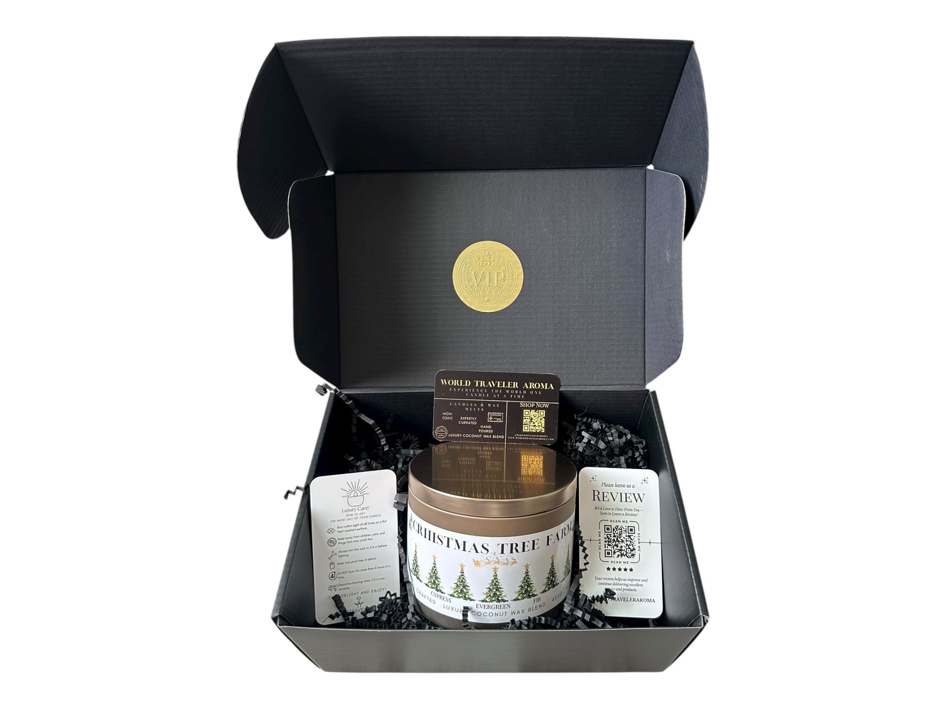 A black gift box with a gold VIP sticker on the lid inside the box a gold candle tin labeled "Christmas Tree Farm" a candle care care instructions, a please review us card, and a World Traveler Aroma business card on a white background.
