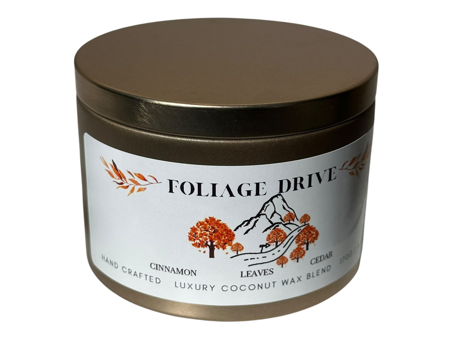 A gold candle tin  with 'Foliage Drive' label on a white background.