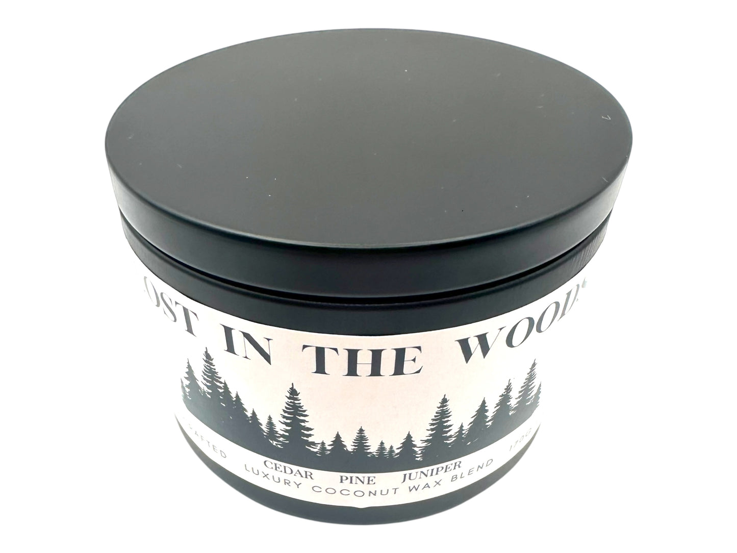  A black candle tin labeled "Lost in the Woods" on a white background. 