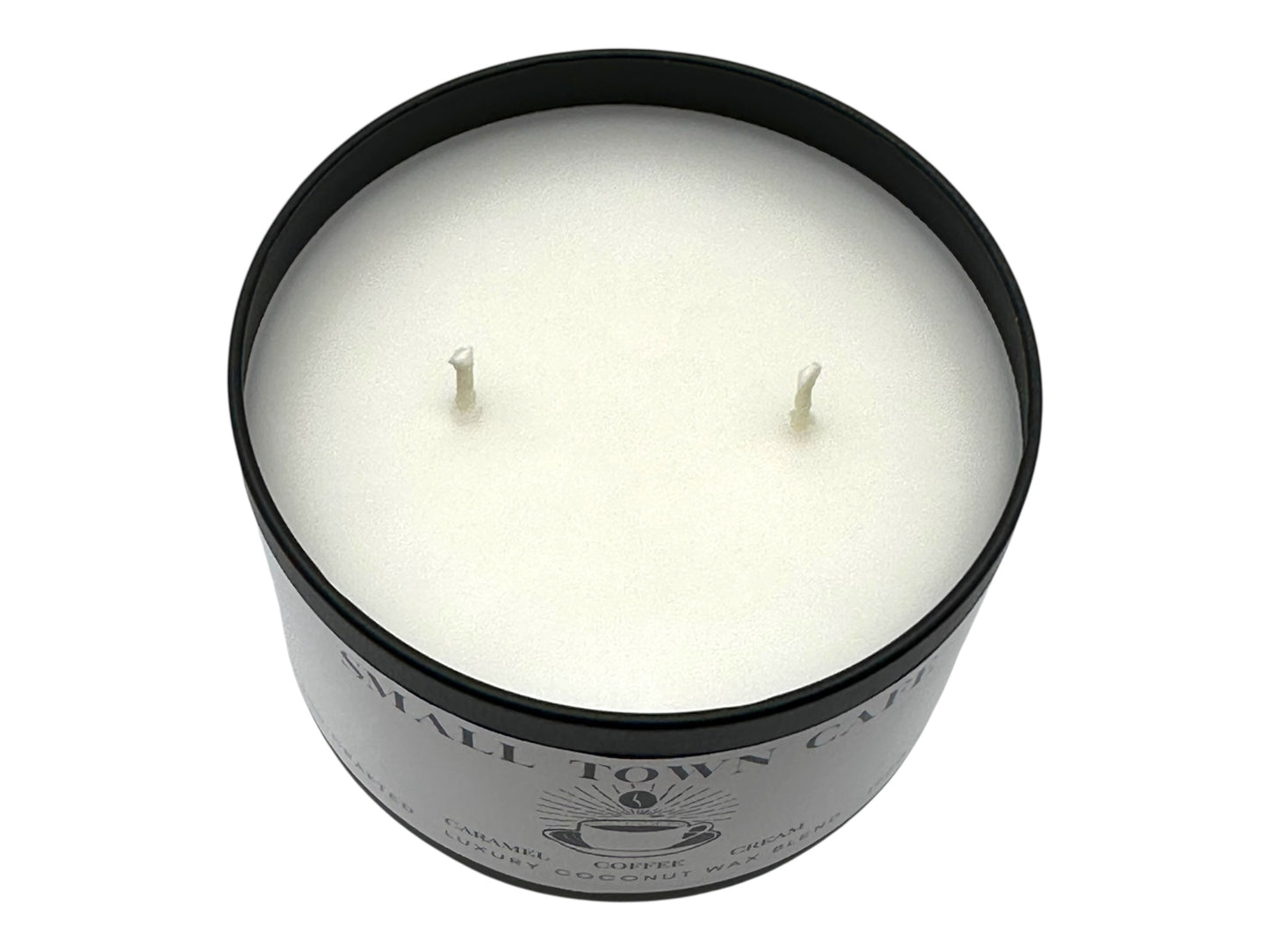 A black candle tin labeled "Small Town Cafe" with lid removed showing two candle wicks and a smooth white candle top on a white background.