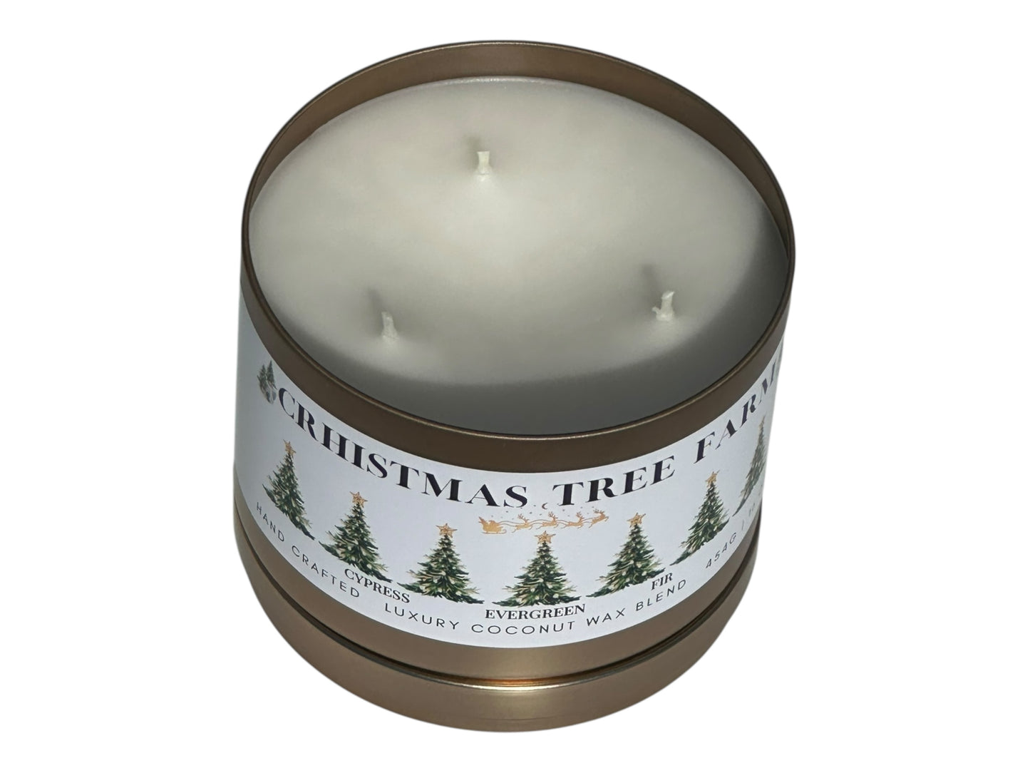 A gold candle tin labeled "Christmas  Tree Farm" on a white background top view with the candle lid removed showing three candle wicks.