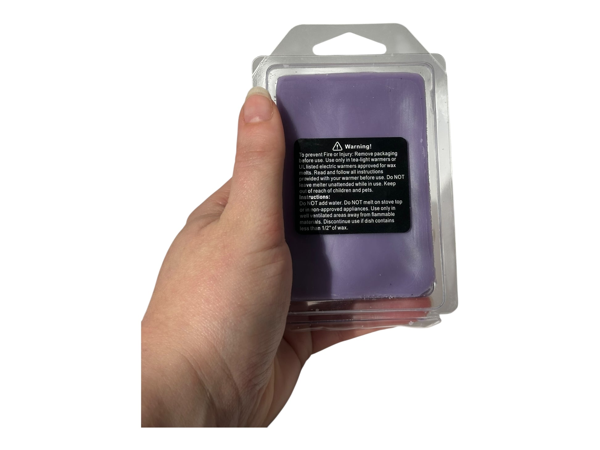 Hand holding a purple wax melt package with warning label on a white background