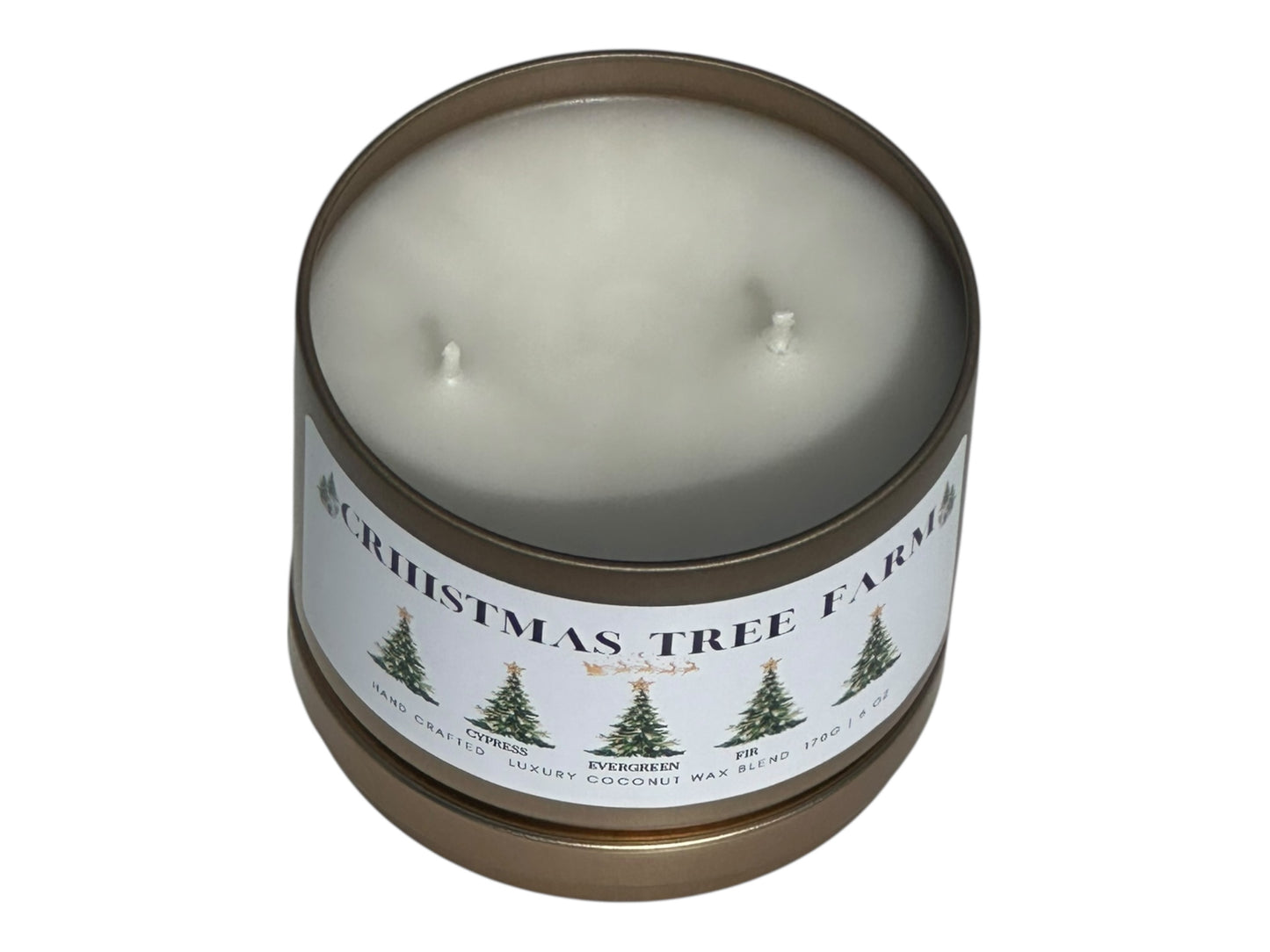 a gold candle tin labeled "Christmas Tree Farm" with lid removed on a white background front view with lid under candle.