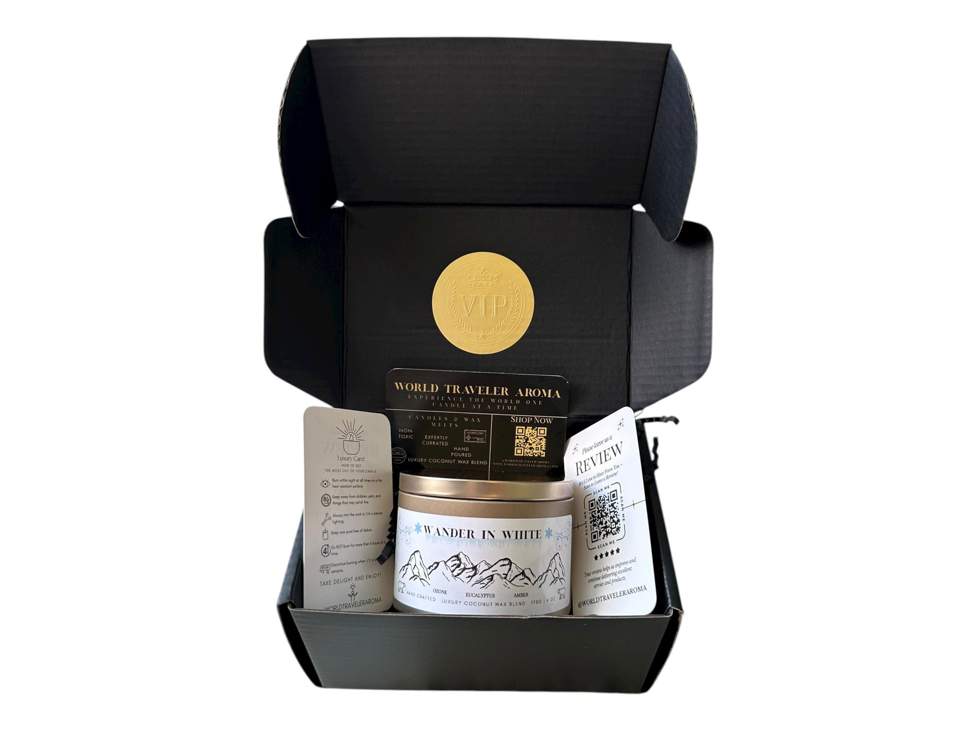 Black gift box with a gold VIP sticker on the lid inside the box a gold candle tin labeled "Wander in White" a candle care card instructions, a please review us card, and a World Traveler Aroma business card on a white background.