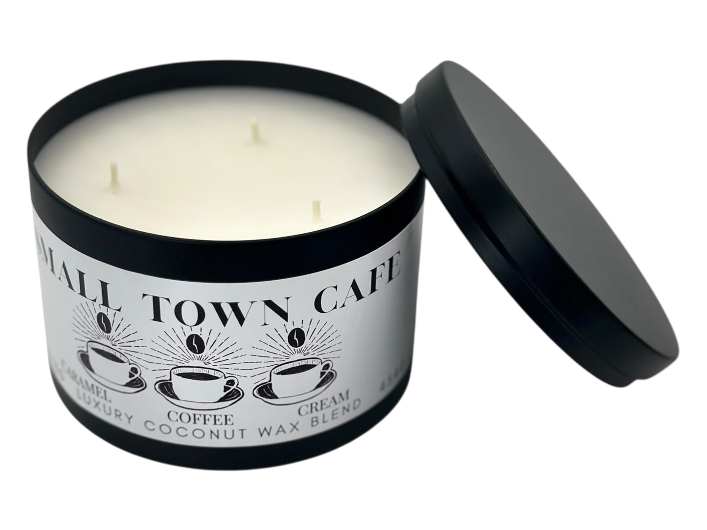 A black candle tin labeled "Small Town Cafe" with lid removed and laid next to the candle showing three wicks and a white smooth candle top on a white background.
