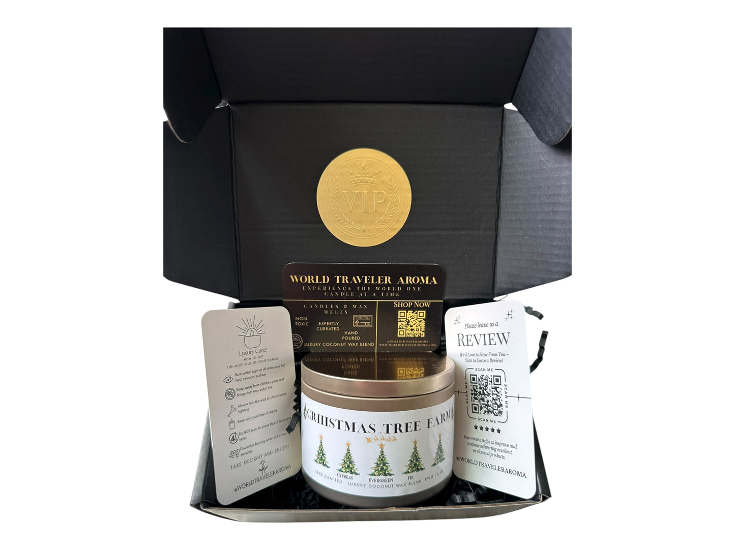 A black gift box with a gold VIP sticker on the lid inside the box a gold candle tin labeled "Christmas Tree Farm" a candle care care instructions, a please review us card, and a World Traveler Aroma business card on a white background.