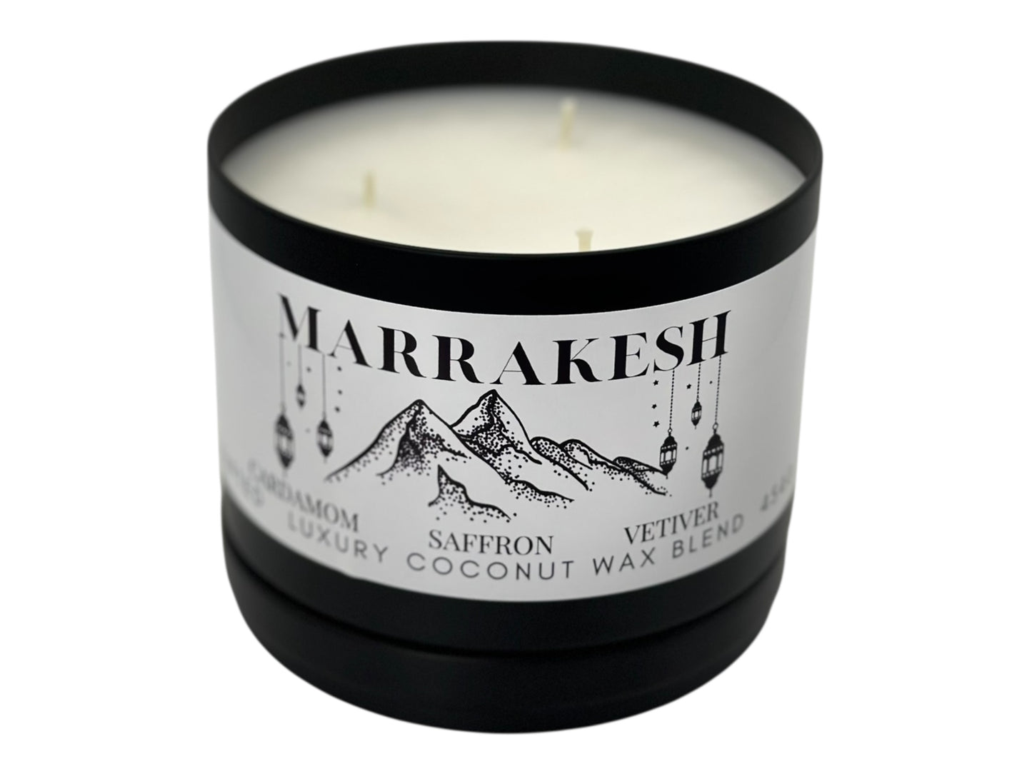 A black candle tin labeled "Marrakesh" lid removed showing three wicks and smooth white candle top on a white background.