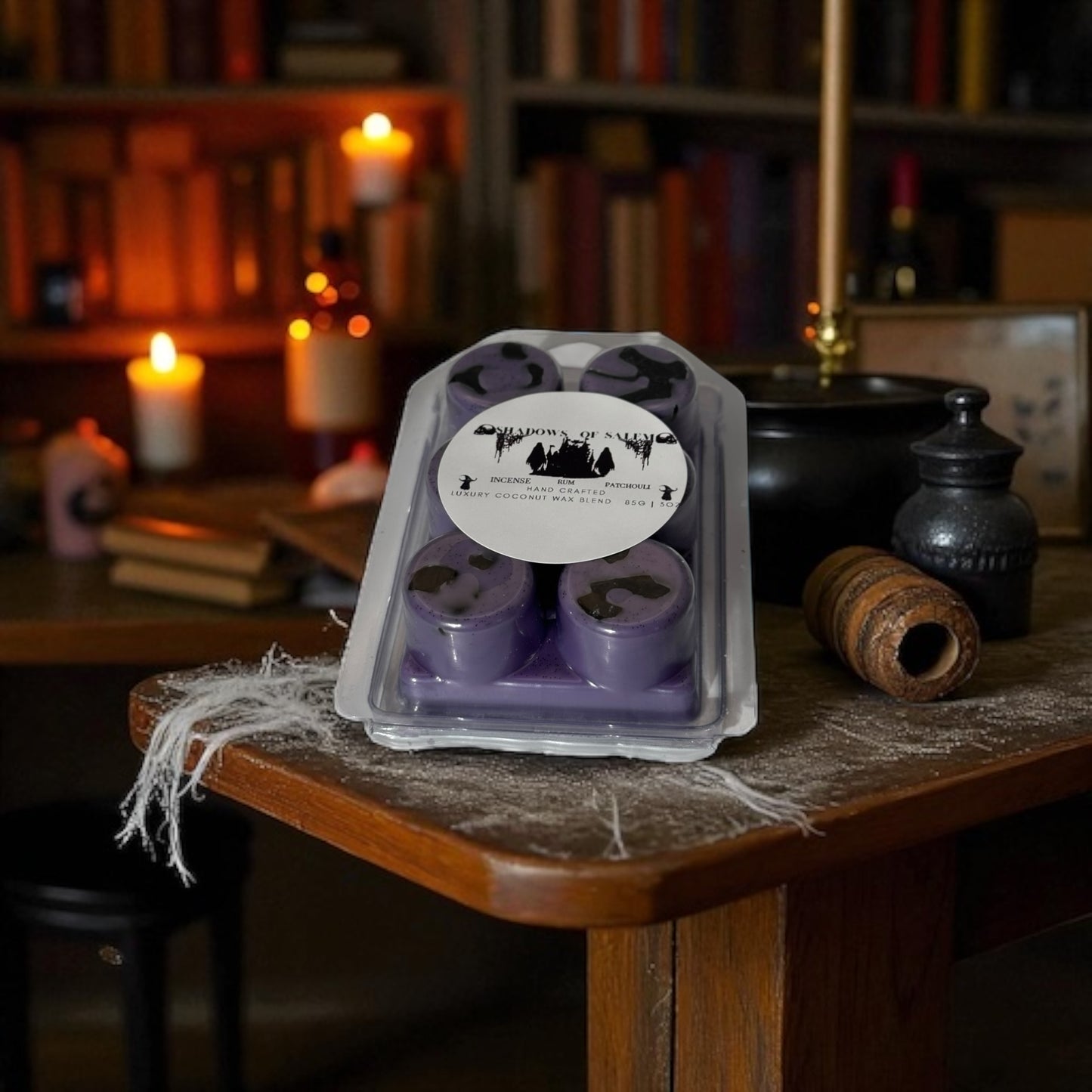 A package of purple 'Shadows of Salem" wax melts on a wooden table with a bookshelf background.