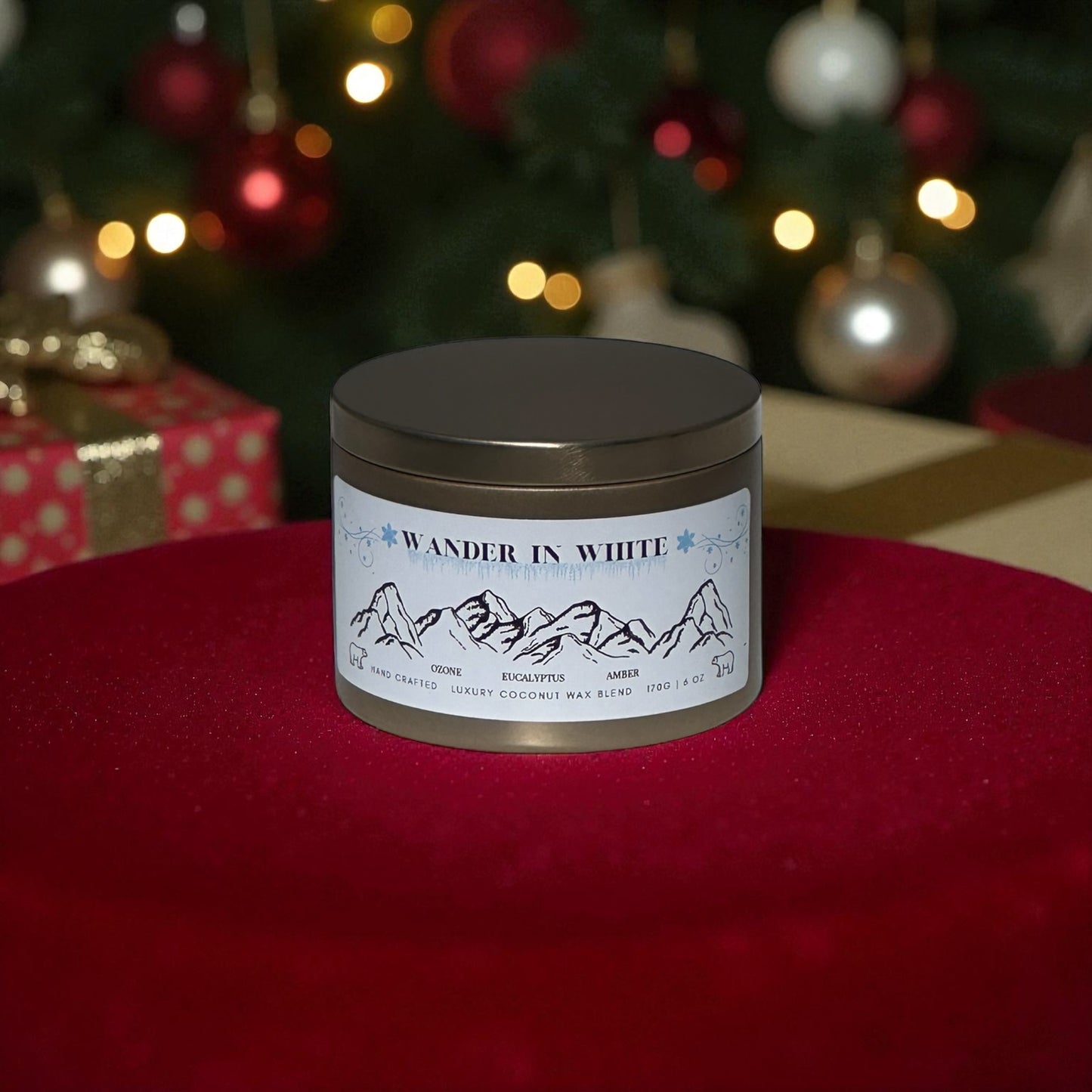 A gold candle tin lambed "Wander in White" on a red rug with Christmas presents and a decorated  Christmas Tree in the background. 