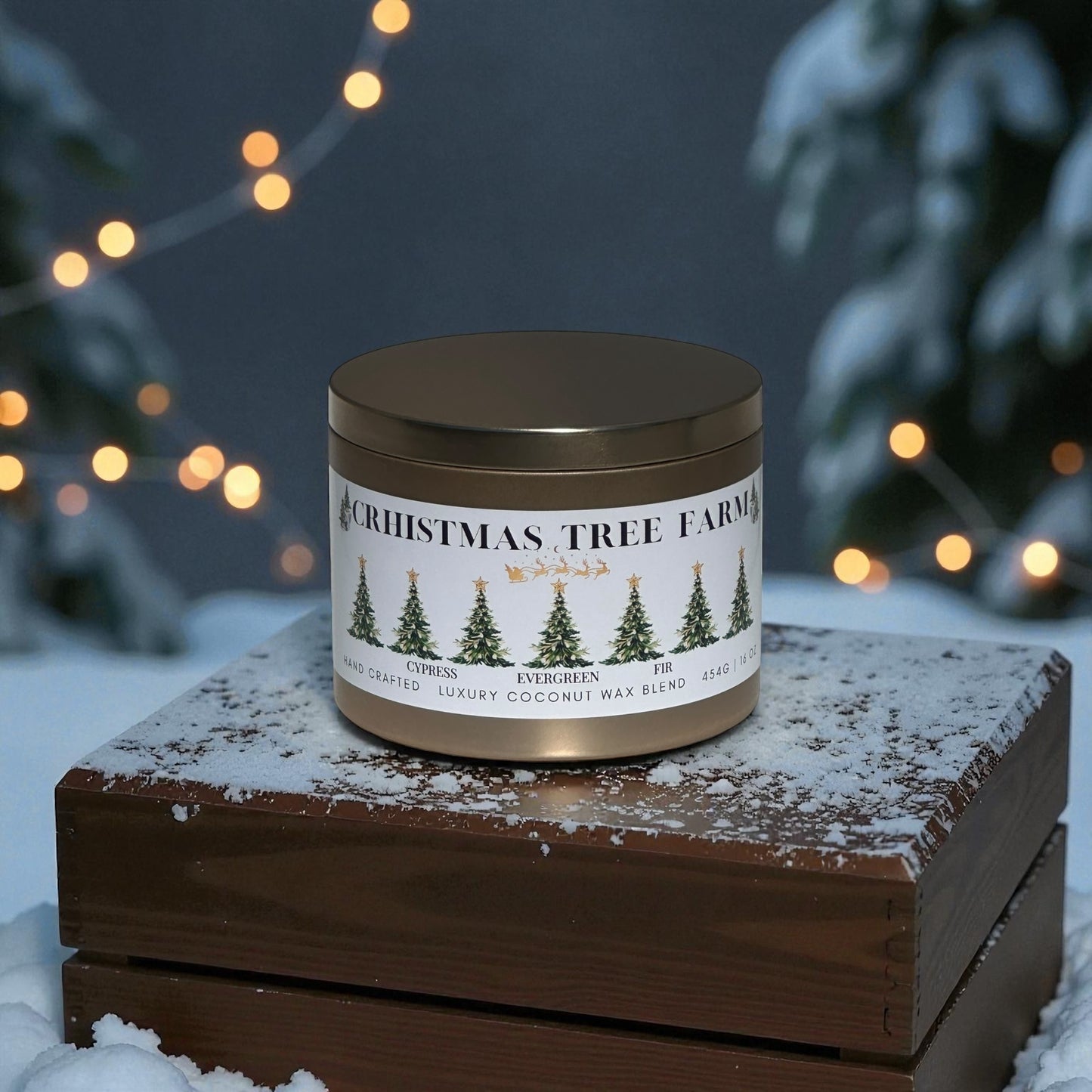 A gold candle tin labeled "Christmas Tree Farm" sitting on a wooden box snow covered ground with snow covered trees and Christmas lights in the background.