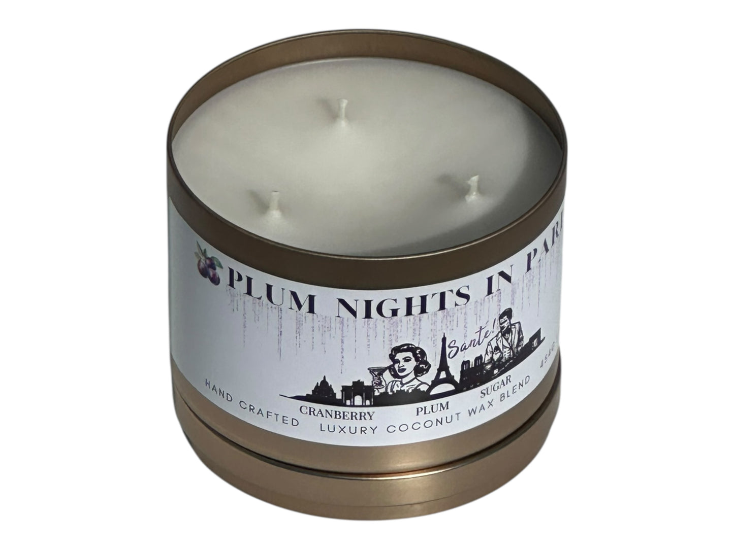 A gold candle tin labeled "Plum Nights in Paris" on a white background front view with candle lid removed.