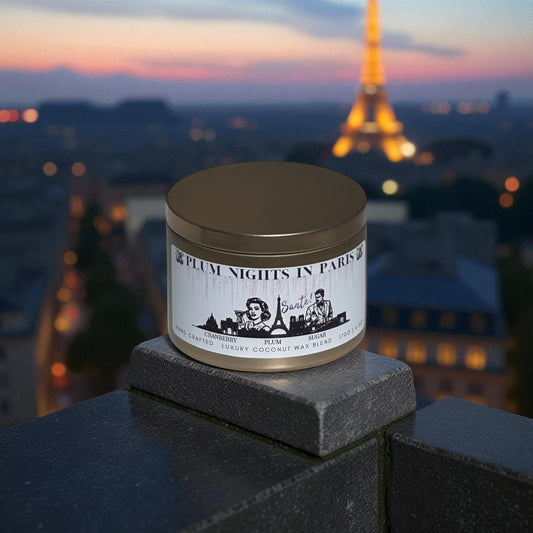 A gold candle tin labeled "Plum Nights in Paris" on a balcony over looking Paris and the Eiffel Tower at dusk.
