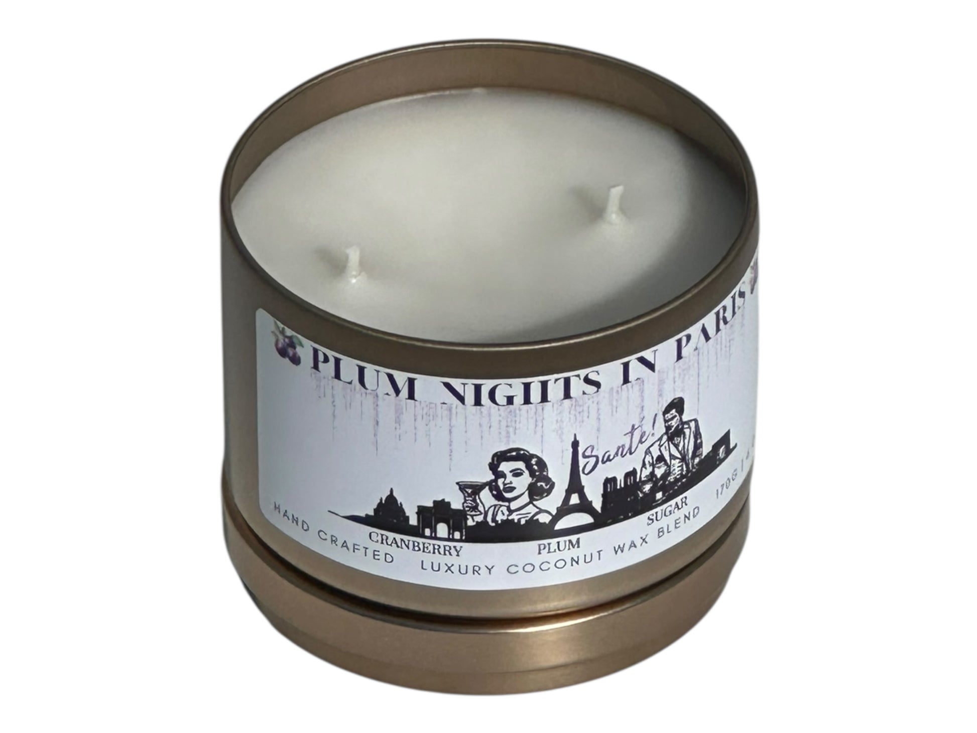 A gold candle tin labeled, "Plum Nights in Paris" on a white background with lid removed top view.
