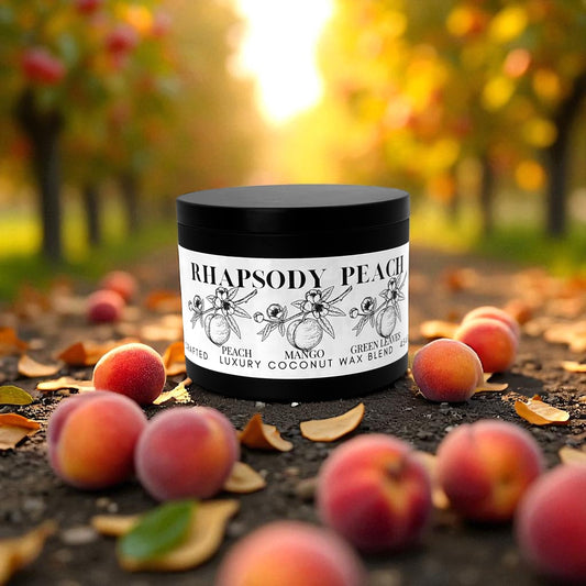 A black candle tin labeled Rhapsody Peach resting on the ground surrounded by peaches and peach trees in the background.