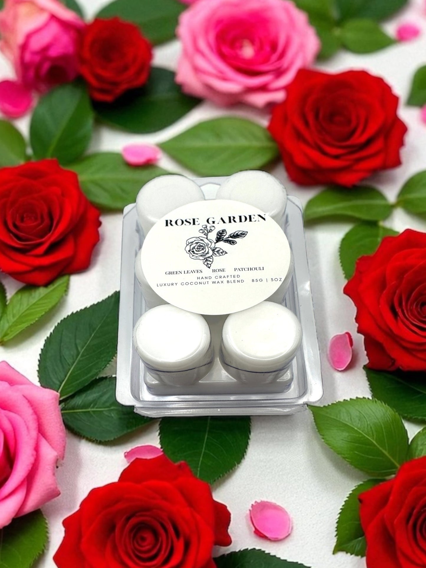 Rose Garden wax melts packaging surrounded by red and pink roses on a white background