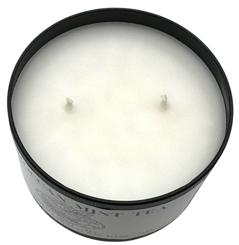 White candle in a black container on a white background