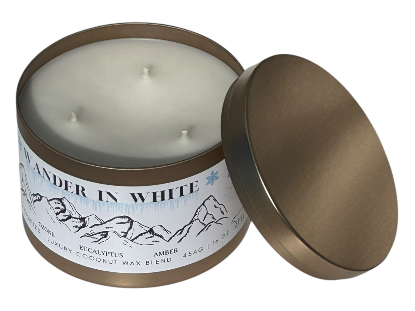 A gold winter candle tin labeled "Wander in White" on a white background.