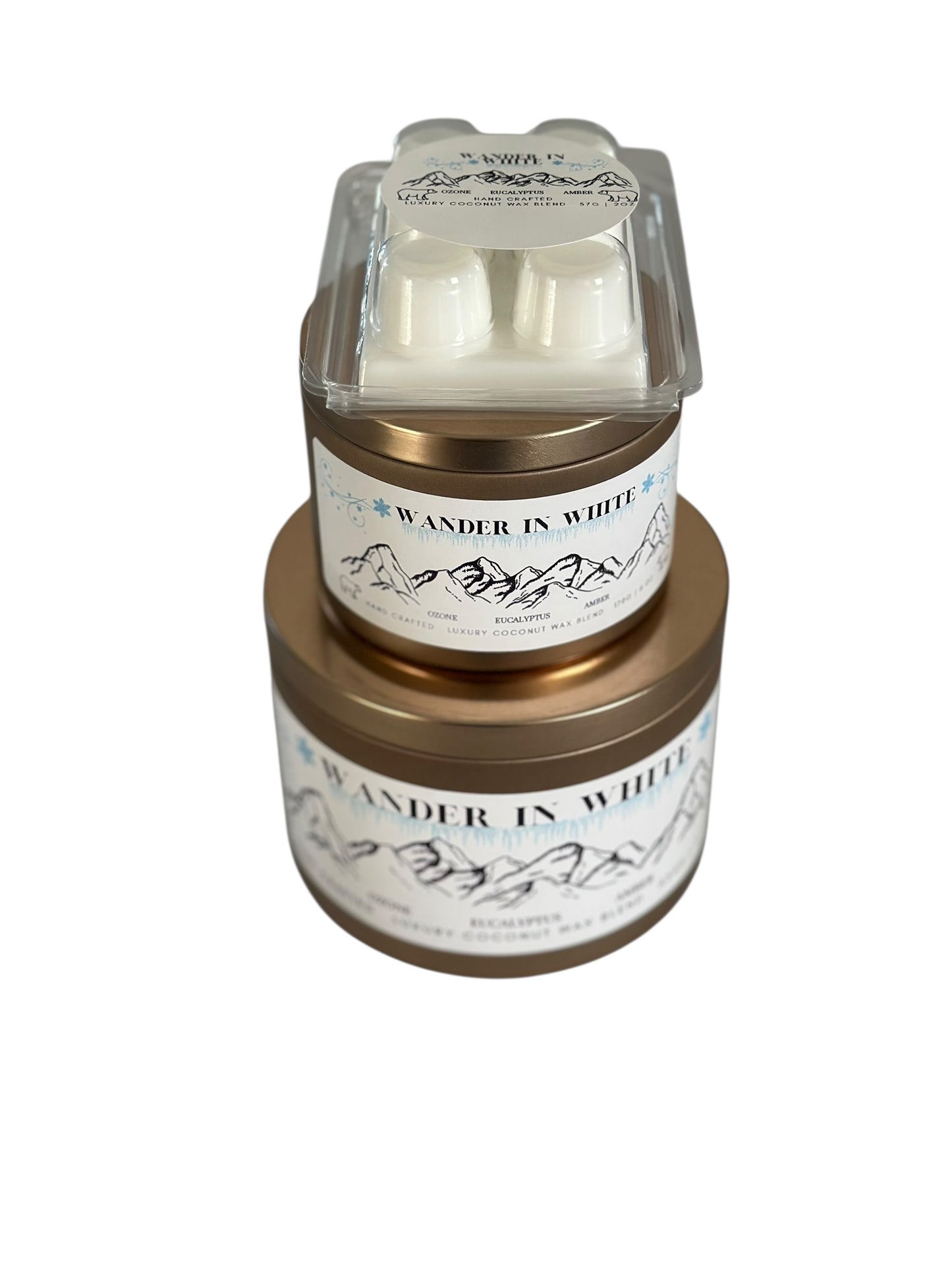 A winter collection of gold candle tins and white coconut wax melt labeled "Wander in White" on a white background.