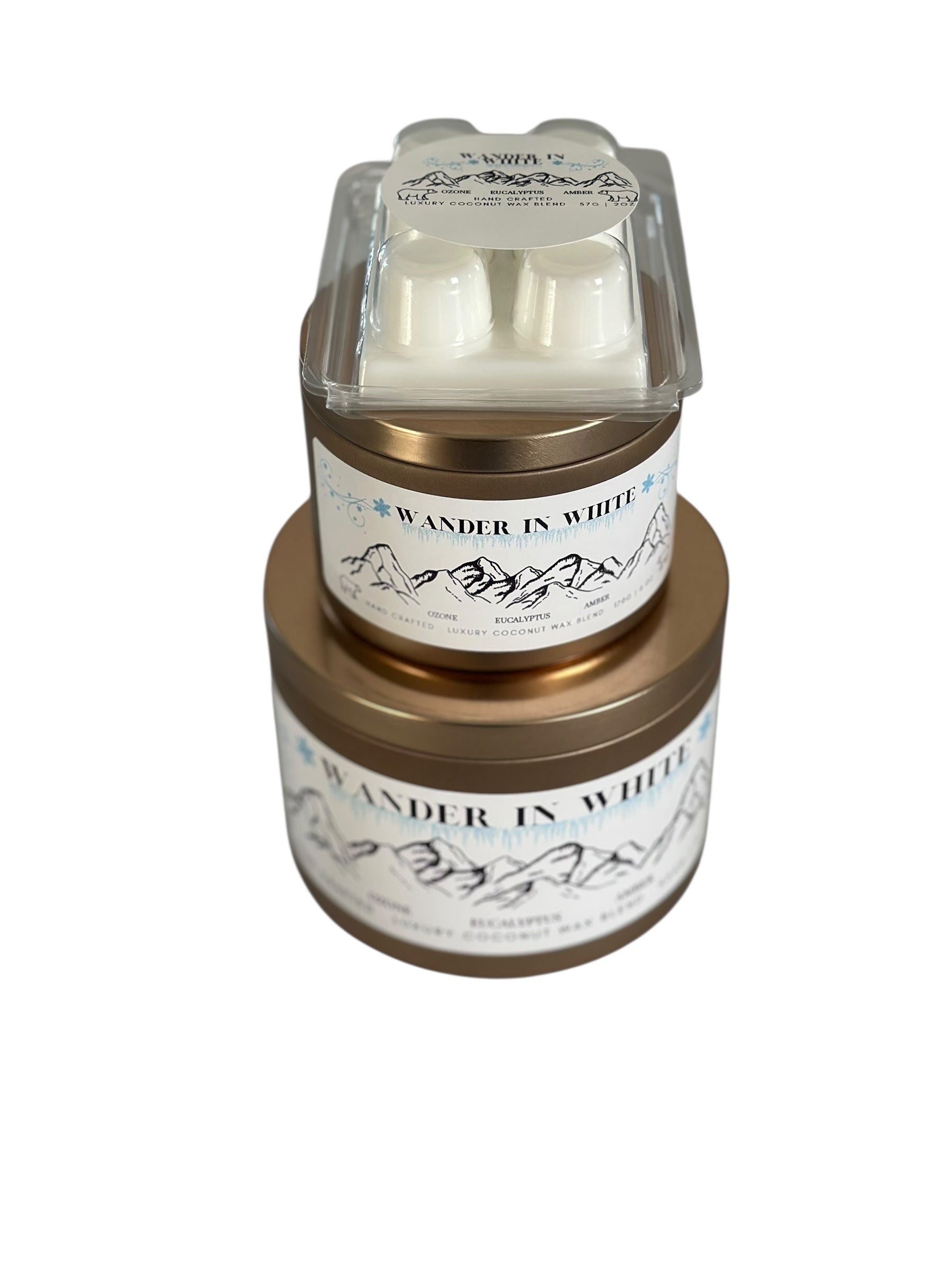 A winter collection of gold candle tins and white coconut wax melt labeled "Wander in White" on a white background.